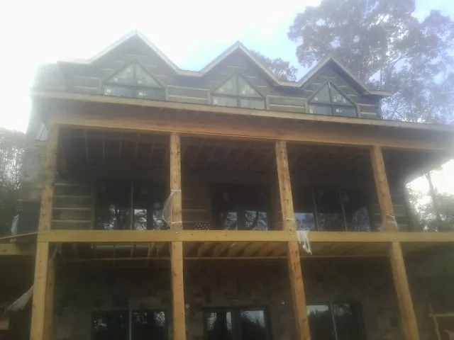 Dormers and porch framing on a large log home under construction — Roof Coating work by our crew in Isleton